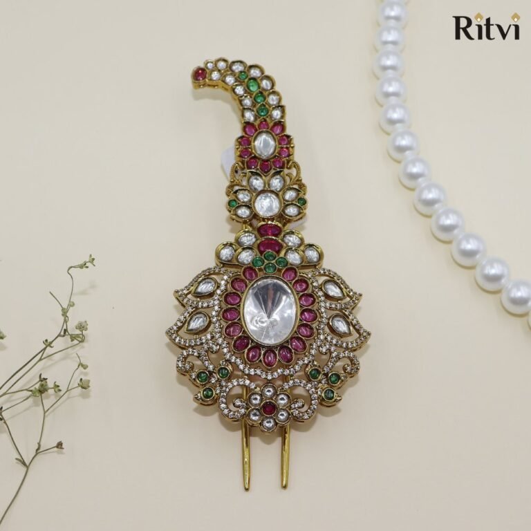 Gold-toned Kundan bridal hair accessory with pink and green stones and intricate traditional detailing