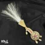 White feather groom kalgi with intricate Kundan detailing, sparkling stones and pearl fringe for Indian wedding