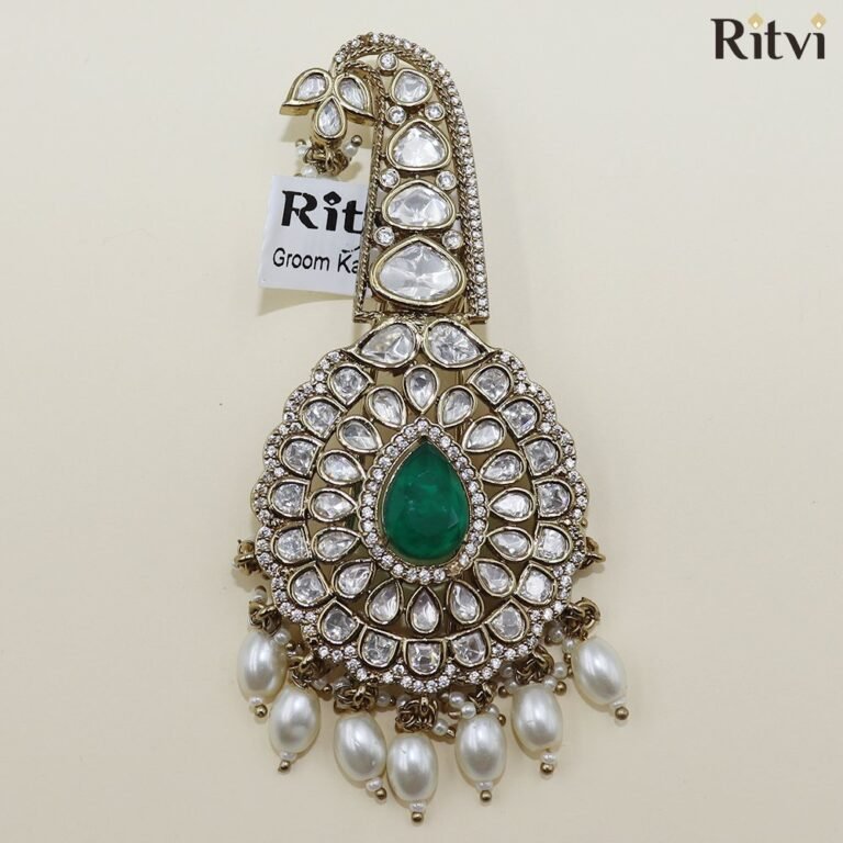 Luxury Kundan groom kalgi with emerald green centre stone, sparkling white stones, intricate gold detailing and pearl drops for Indian wedding