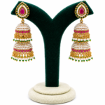 Panchhi gold-plated pearl jhumka earrings with ruby pink and emerald green stones, traditional bridal earrings for weddings, festive and ethnic wear.
