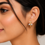 Gold-plated leaf design huggie bali earrings with round cubic zirconia stones, elegant lightweight hoop earrings for women on a white background.
