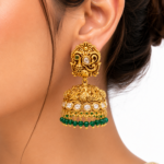 Gold-plated peacock jhumka earrings with kundan stones, antique finish, and green bead drops for bridal and festive ethnic wear.